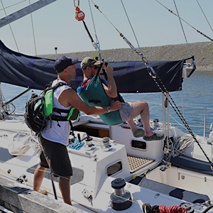 Matt Debicki using dockside lift to assist a disabled man in boarding a sailboat