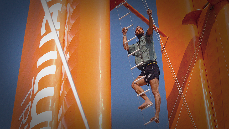 Able Sail N.L. president Matt Debicki climbing rigging ladder of large racing sail boat.